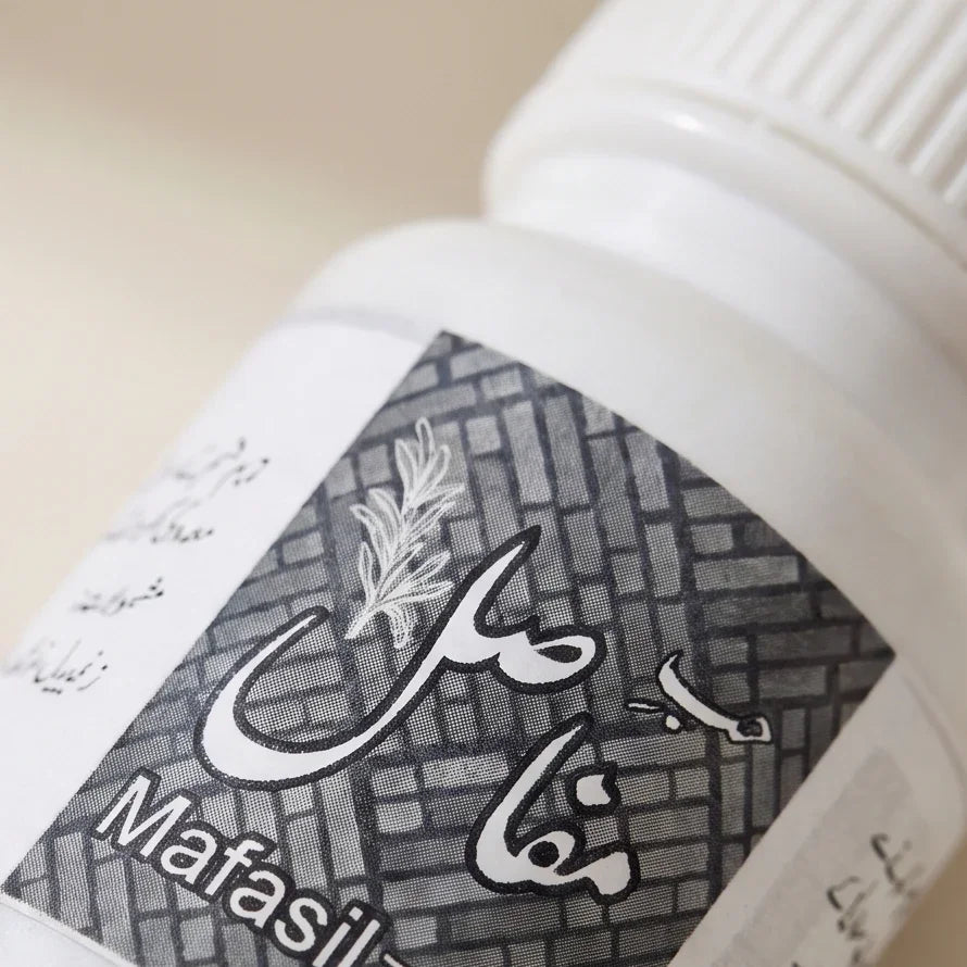 White bottle of Mafasil Unani herbal remedy with traditional Urdu calligraphy.